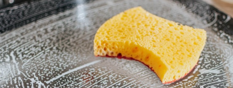 Gul svamp på såpig, våt yta med ränder och bubblor